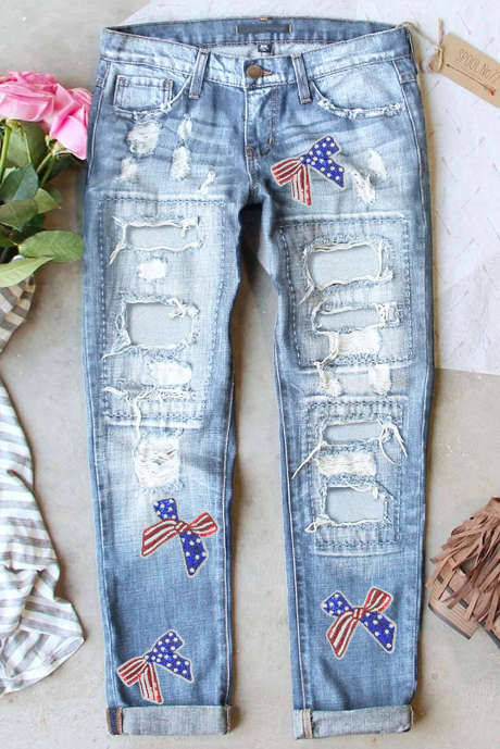 Jeans strappati con motivo a bandiera azzurra e fiocco in paillettes