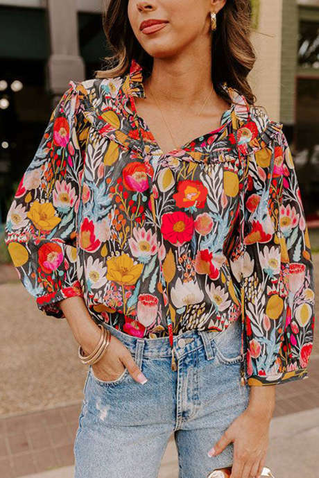 Blusa negra con estampado floral, mangas abullonadas 3/4 y cuello anudado
