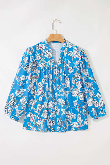 Nebesno modra bluza z V-izrezom in cvetličnim potiskom ter 3/4 napihnjenimi rokavi