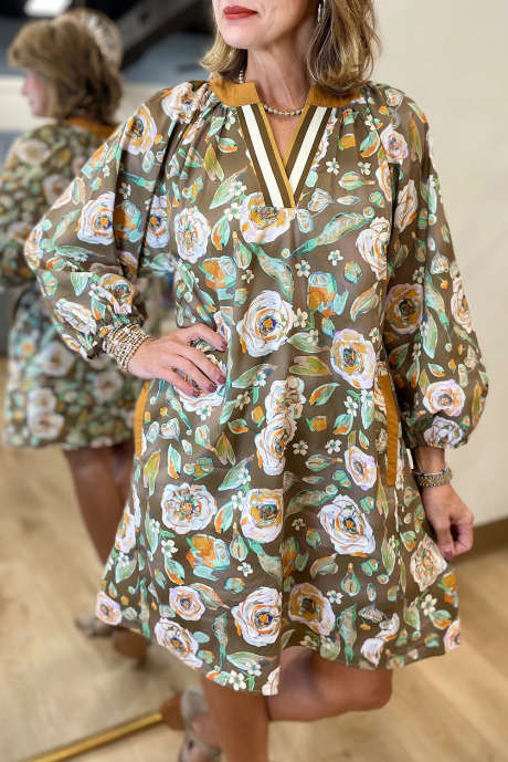 Vestido curto marrom com estampa floral contrastante, decote em V e bolsos, manga comprida