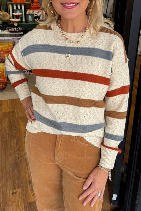 سترة محبوكة مخططة باللون البيج مع درزات مكشوفة وأكتاف منسدلة