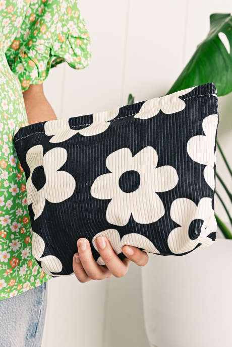Bolsa de cosméticos texturizada com estampa de flor preta e nervuras