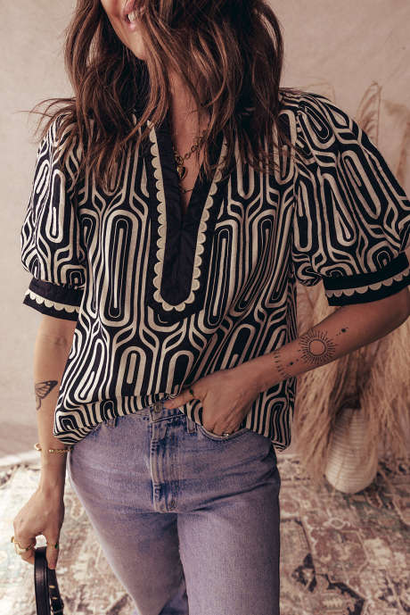 Schwarze Bluse mit geometrischem Muster, kontrastierendem Muschelsaum und Farbblock-Patchwork-Details, Kurzarm