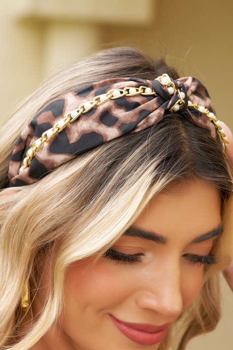 Faixa de cabelo larga com estampa de leopardo castanho e detalhe de corrente de pérolas com nós.