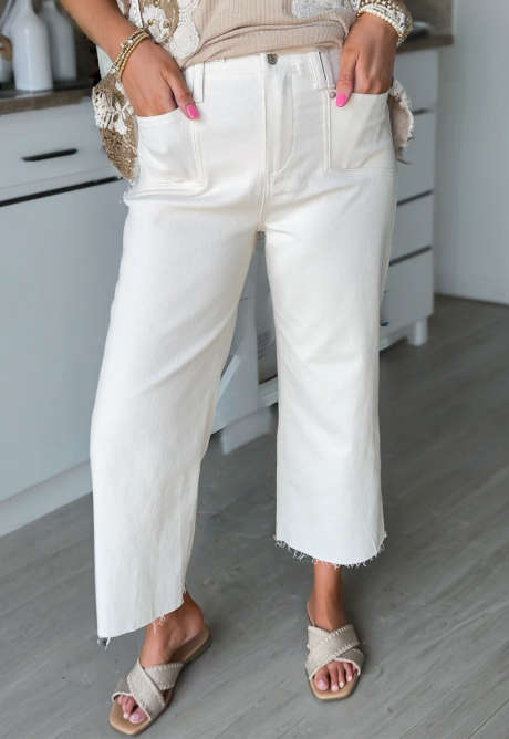 Białe, luźne jeansy z surowym brzegiem i długością do kostek