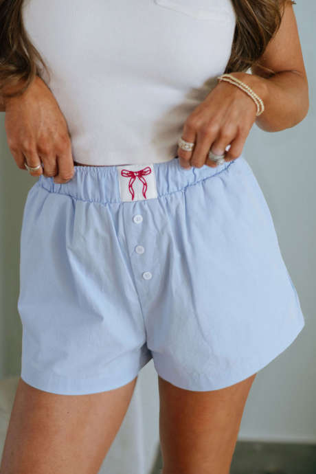 Pantalones cortos tipo caja con cintura elástica, detalle de lazo bordado y botones en azul Beau
