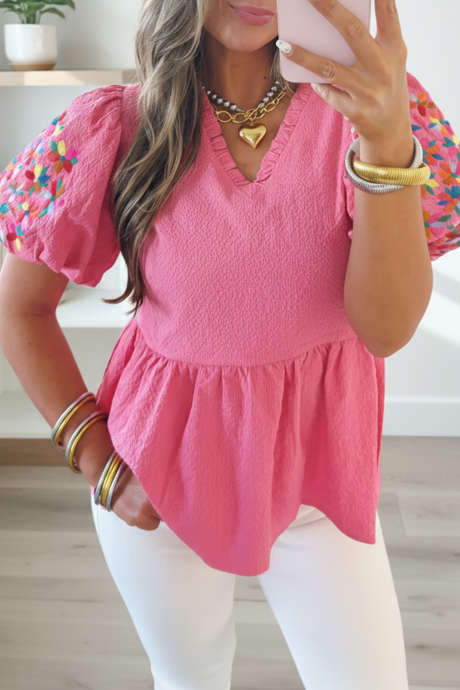 Chemisier texturé rose poudré à col en V à volants et broderie florale, manches bouffantes.