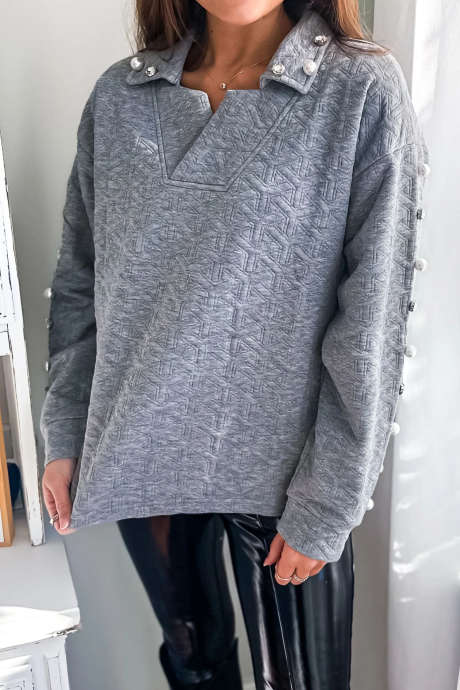 Lichtgrijze gewatteerde top met lange mouwen en parelmoeren textuur en versierd met strass