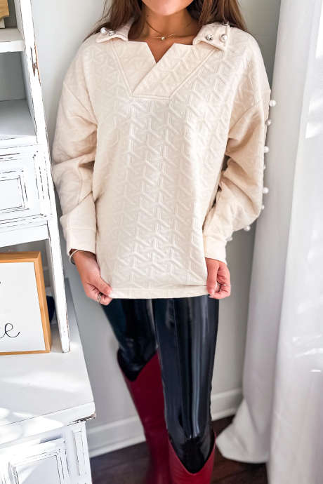 Beige gewatteerde textuur met parelmoer en strass-steentjes versierde top met kraag en lange mouwen
