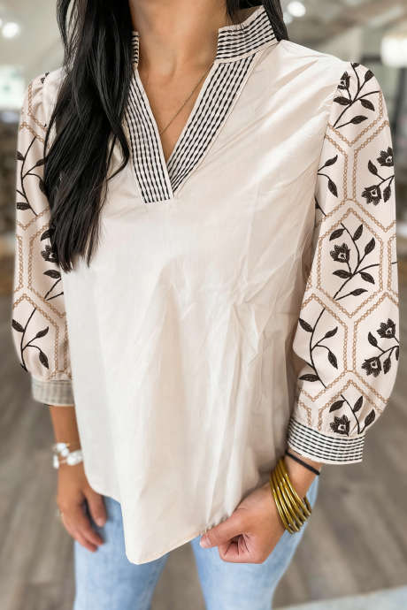 بلوزة بيضاء مزخرفة بنقشة زهور وأكمام منتفخة ورقبة على شكل حرف V