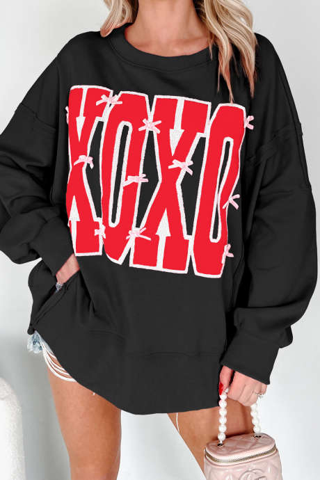 Zwarte XOXO-sweater met strik en pailletten, met zichtbare naden en een grafische letterprint