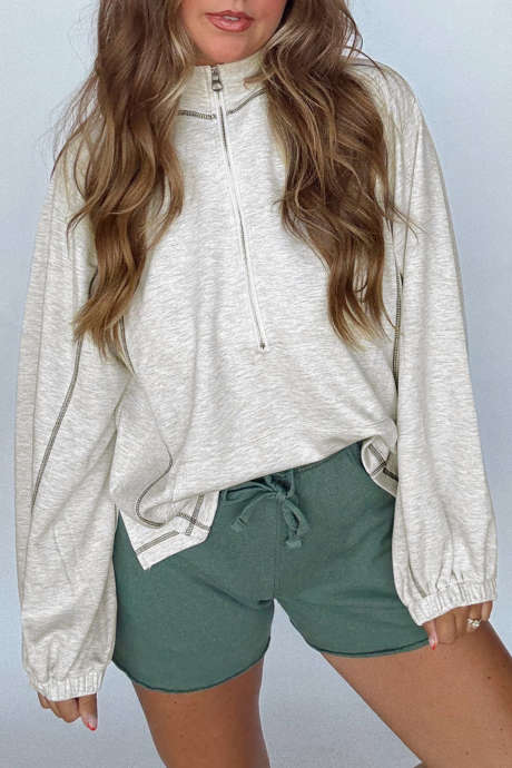 Haut gris clair à demi-zip, col montant et manches longues, détail coutures apparentes