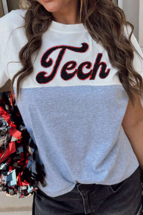 Grijze T-shirt met kleurblokken, patchwork, pailletten en technische letters.