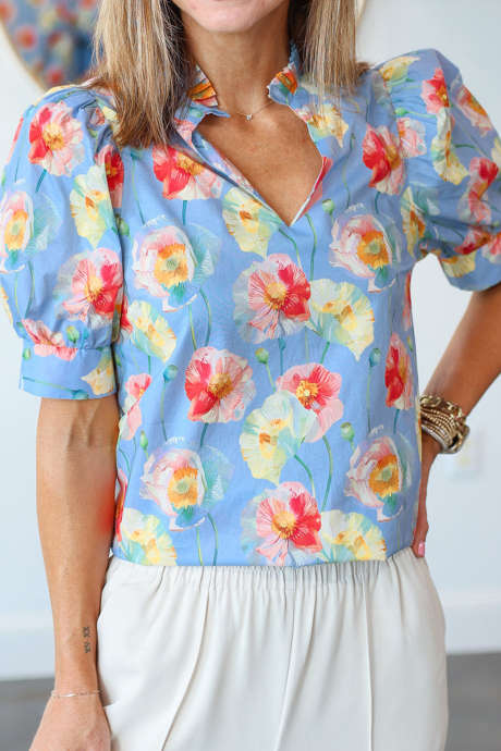 Hemelsblauwe blouse met klaprozenprint, geplooide kraag en korte pofmouwen