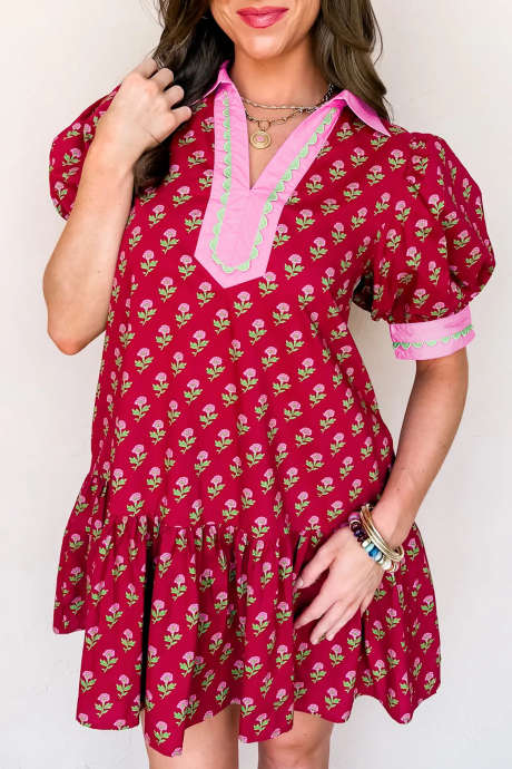 Röd blommig klänning med kontrasterande v-ringning och korta bubbelärmar