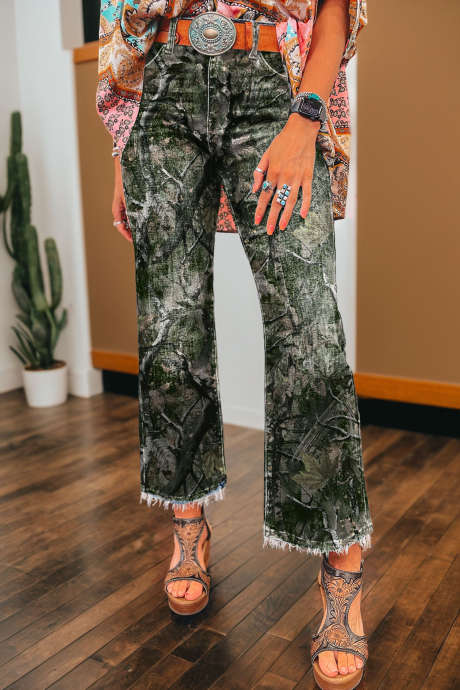 Gröna abstrakta lövrika kamouflagemönster med rå fåll och ankellånga jeans
