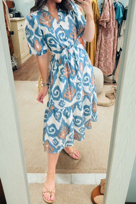 Vestido midi azul celeste com estampa floral boho, mangas curtas bufantes, fechamento frontal com botões e barra com babados.