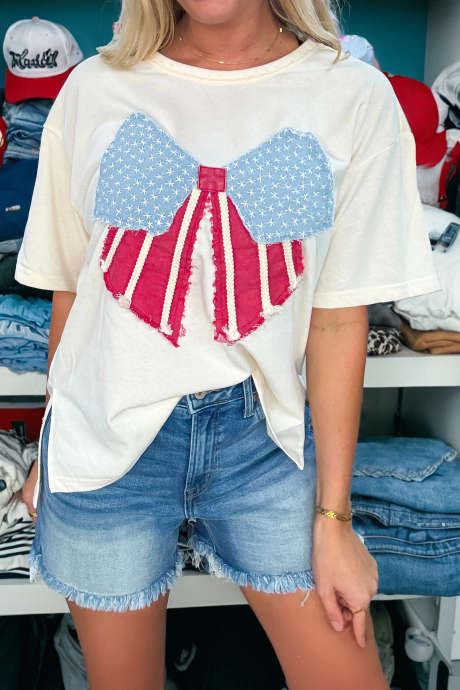 Biała luźna dzianinowa koszulka z kokardą i naszywką w stylu vintage z flagą