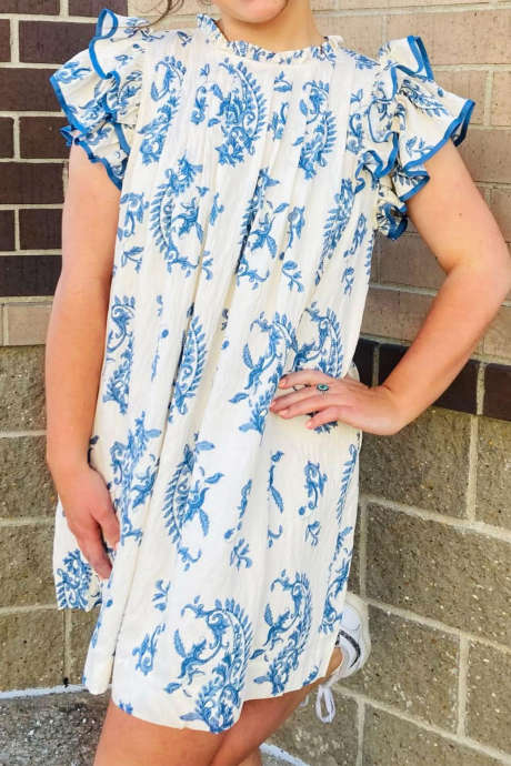 Nebesky modré šaty pro větší děti s botanickým potiskem, knoflíky, kontrastním lemem, volánky a rukávy