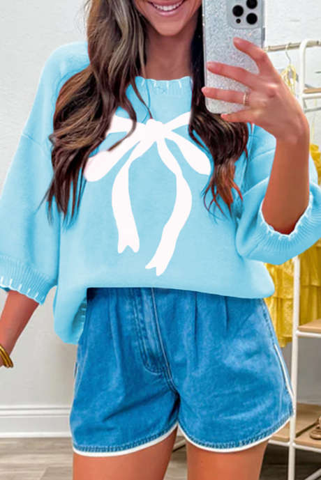 Jasnoniebieski sweter z dużą kokardą i kontrastowymi przeszyciami, z obniżonymi ramionami