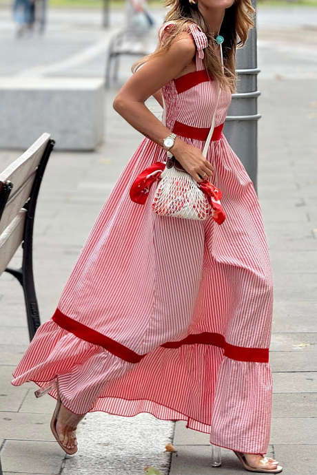 Punainen raidallinen rusettisolmuilla koristeltu maksimekko, jossa kontrastiväriset reunukset ja korkea vyötärö, röyhelöhelma