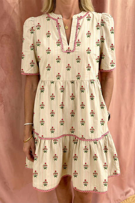 Aprikosstripete blomstertrykk med kontrastdetaljer og rysjer i kanten