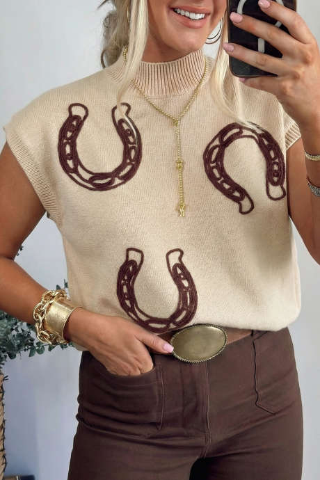 Pergamenttinyörillä koristeltu hevosenkenkäkoristeinen lyhythihainen neulepusero, jossa joustinneulos