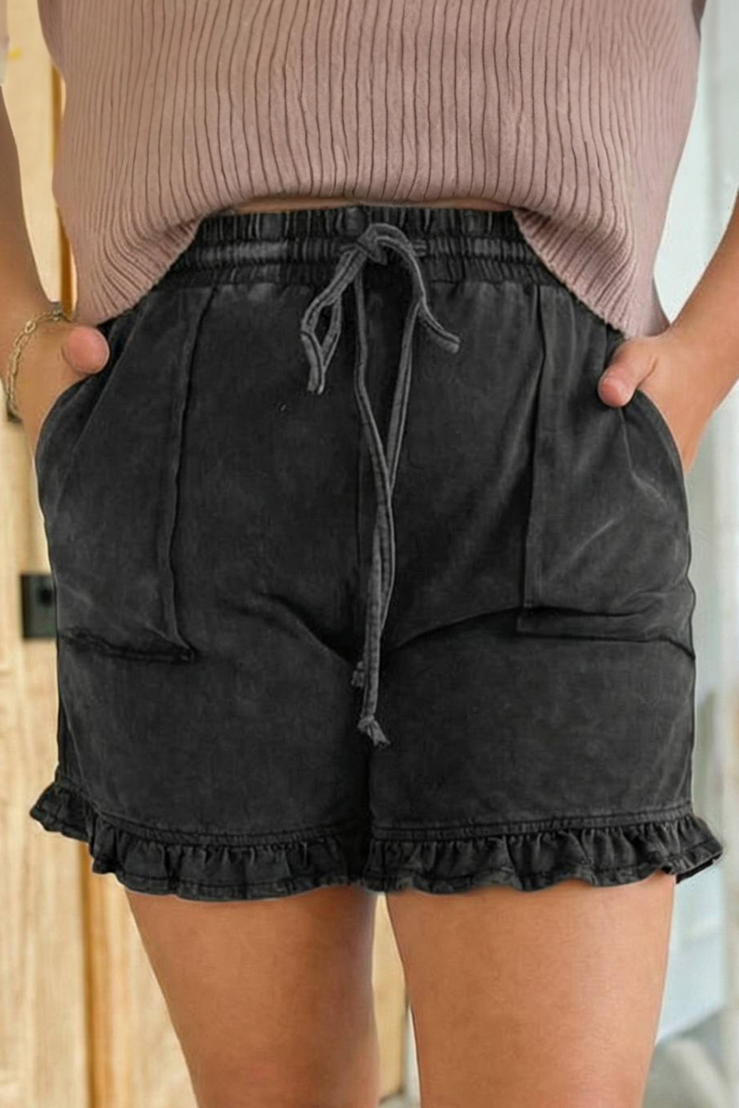 Short grande taille à taille élastique et cordon de serrage, noir délavé, ourlet volanté.