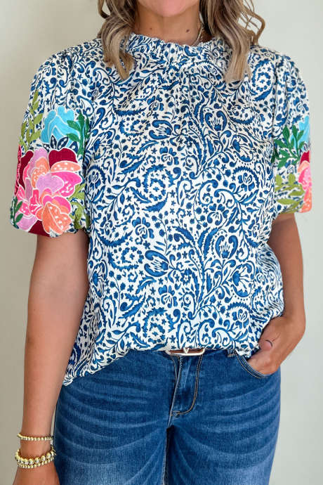 Blå bluse med botanisk trykk og broderte blomster og puffermer