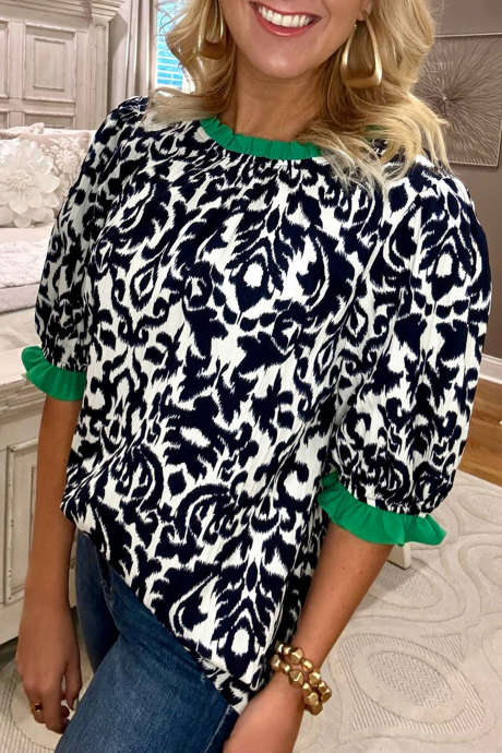 Musta kukkakuvioinen röyhelöinen väriblokkidetaililla varustettu puolihihainen pusero