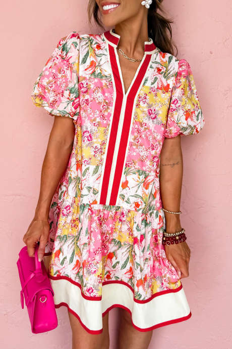 Roza barvno blokovna cvetlična obleka s kontrastnimi obrobami in V-izrezom, nabranim robom