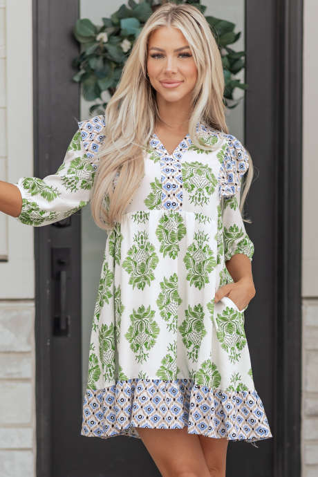 Zelena mini obleka s cvetličnim potiskom in kontrastnimi našitki ter naborki