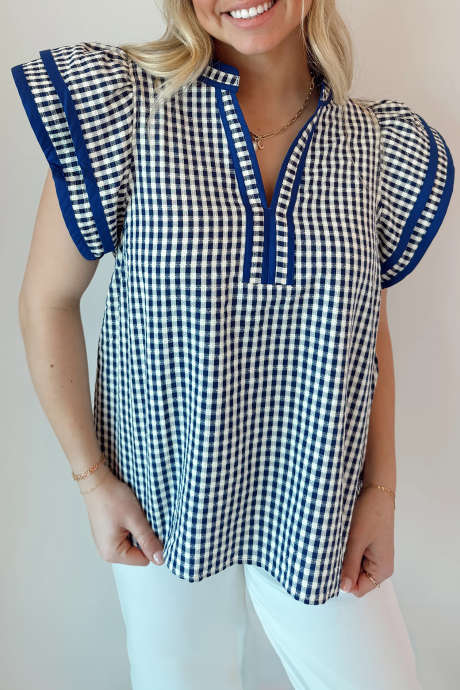 Blue A navy and white checkered short sleeve blouse with ruffle sleeves.