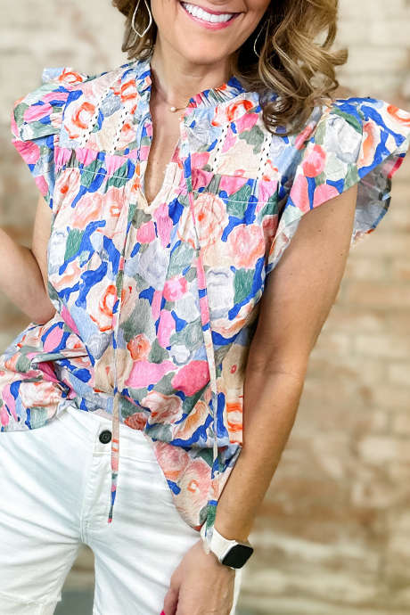 Rosa blomstertrykk med knyting og V-hals, kontrastdetaljer og rysjer, korte ermer