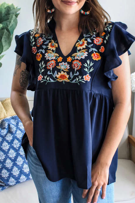 Skittenblå babydoll-bluse med V-hals og rysjermer og blomsterbroderi