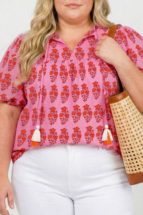 Rosa bluse i pluss-størrelse med blomstertrykk og dusker og puffermer i bomull