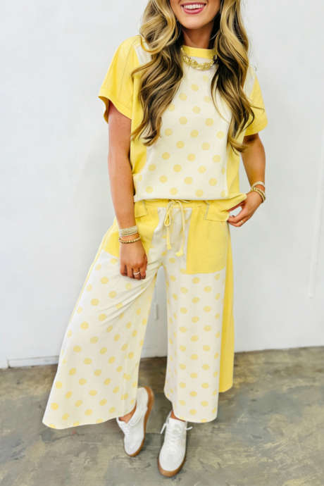 Gult fargeblokk-lappeteppe med polkaprikker og vide benbukser