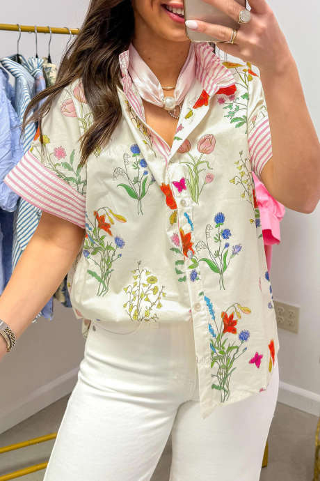 Camisa beige de manga corta con cuello de volantes y estampado floral a rayas.