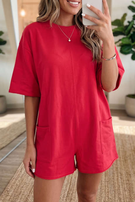 Macacão curto vermelho vibrante com mangas curtas, barra desfiada e bolsos.