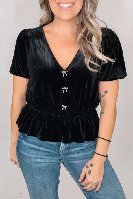 Blusa negra de manga corta con escote en V, detalle de lazo y bajo peplum.
