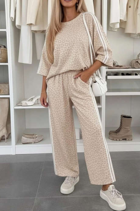 Bộ đồ thể thao gồm áo tay lửng 3/4 và quần ống đứng, họa tiết da báo màu mơ, phối sọc.
