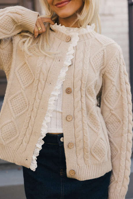 Áo khoác cardigan dệt kim kiểu cáp, màu giấy da, viền ren xếp nếp, cài cúc phía trước.