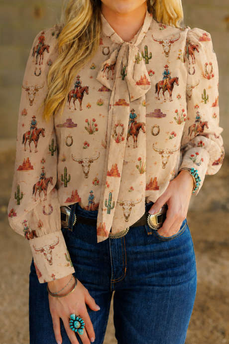 Blusa cáqui com estampa ocidental, decote com laço e mangas compridas.