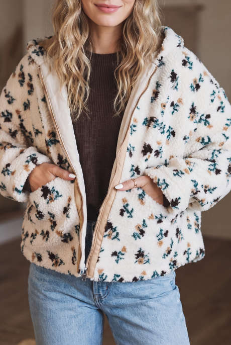 Witte winterjas met capuchon van imitatiebont met bloemenprint en metalen ritssluiting.