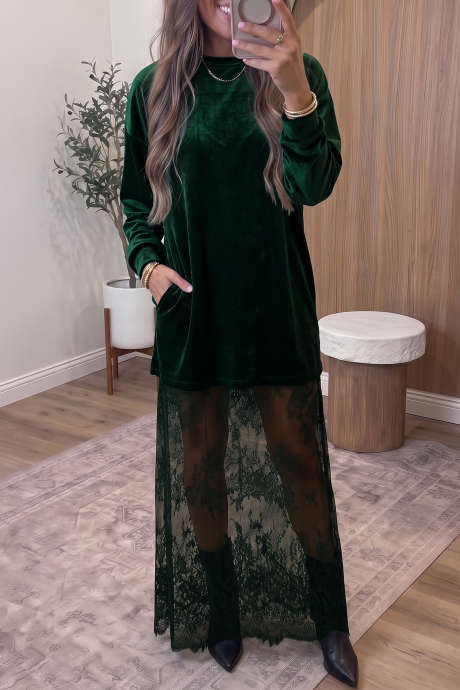 Vestido longo evasê de veludo verde-escuro com mangas compridas e barra com detalhes em renda.