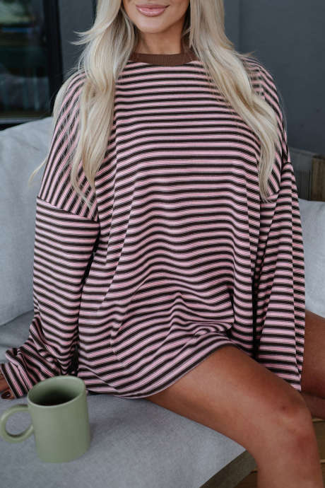 Conjunto de duas peças composto por blusa de manga comprida oversized com listras marrons e shorts casuais com bolsos.