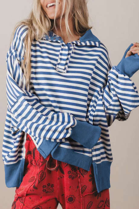 Sweat-shirt ample à rayures bleues, bordures bicolores et coutures apparentes.