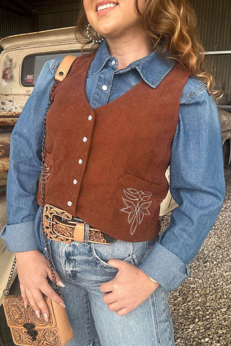 Corduroy vest met V-hals en geborduurd koffiekleurig patroon, opgestikte zak en knoopsluiting.