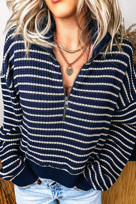 Haut à manches longues en maille texturée à rayures bleues et col zippé.