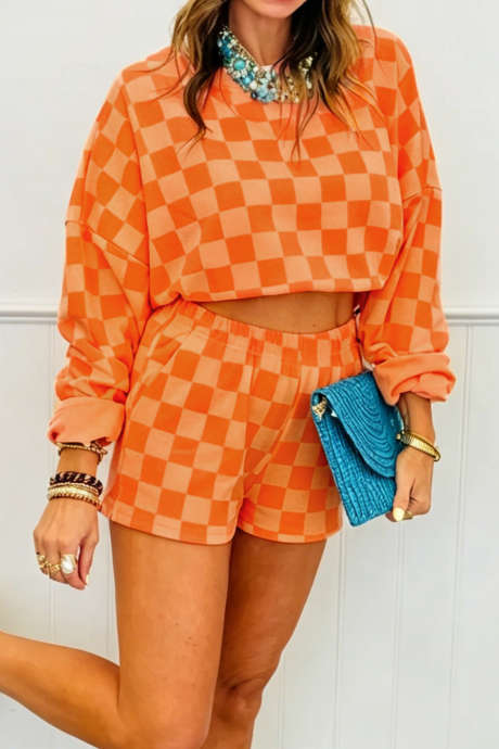 Conjunto de dos piezas: top corto de manga larga a cuadros naranjas y shorts con cintura elástica.
